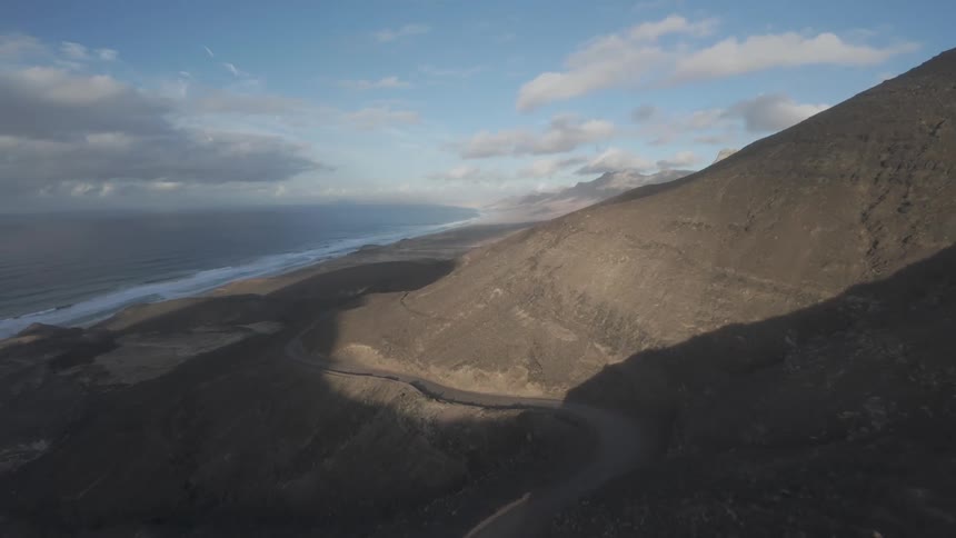 A winding trail on the mountain leads to the shore