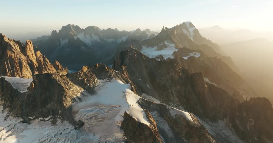Aerial landscape of mountain ranges with cliffs and the suns reflection at dawn