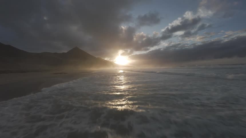 The sun is rising on the beach