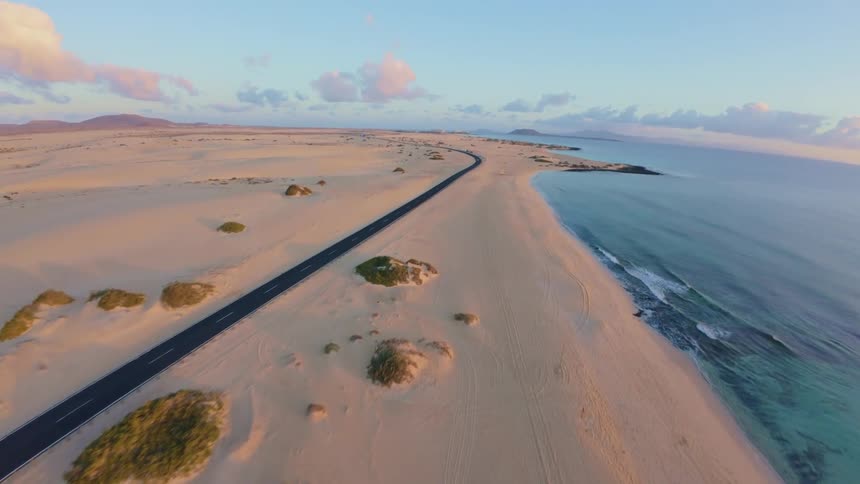 A road weaves by a beach