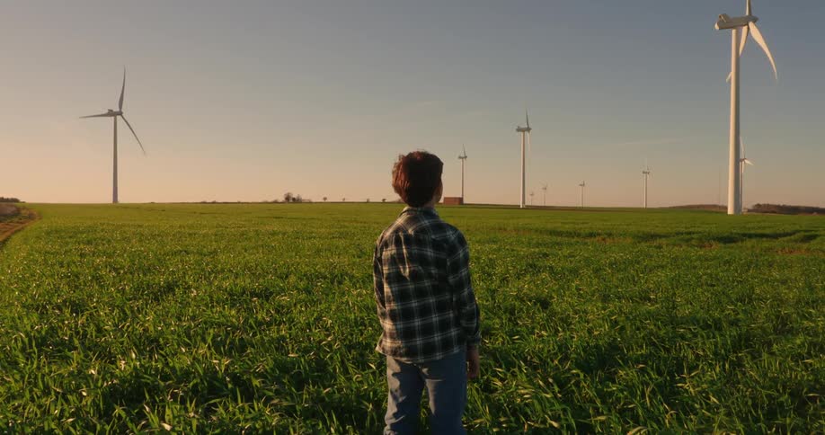 A footage of a boy standing on a grassfield