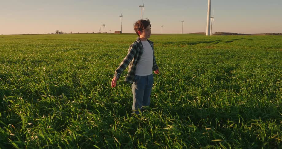 Boy with arms outstretched while standing in a farm field
