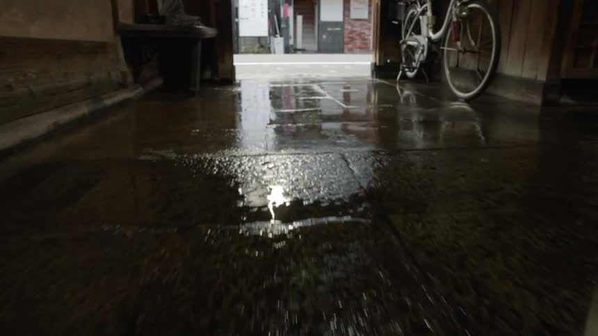 People are walking in the street past the alley