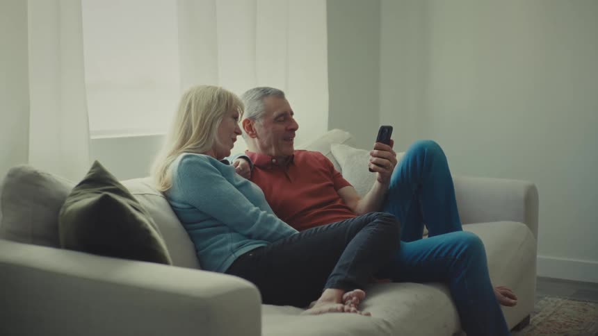 A man and woman are looking at a phone together