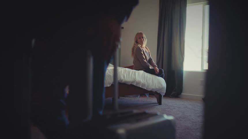 A man wheels luggage out of the room