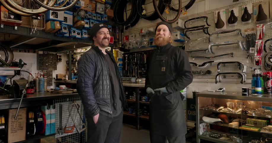 Two smiling men inside a workshop