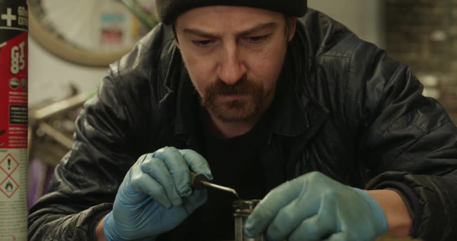 A worker is using a tool to repair a small bike part