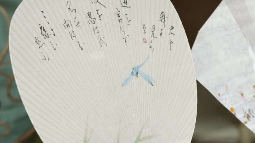 Chinese characters cover a hand fan