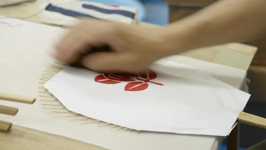 A person works on a fan in a workshop