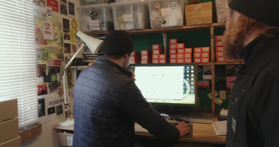 Two men facing a computer screen in a store