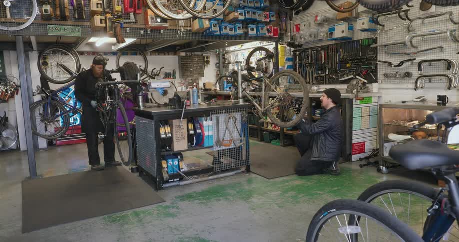 Two men are repairing bikes in the shop