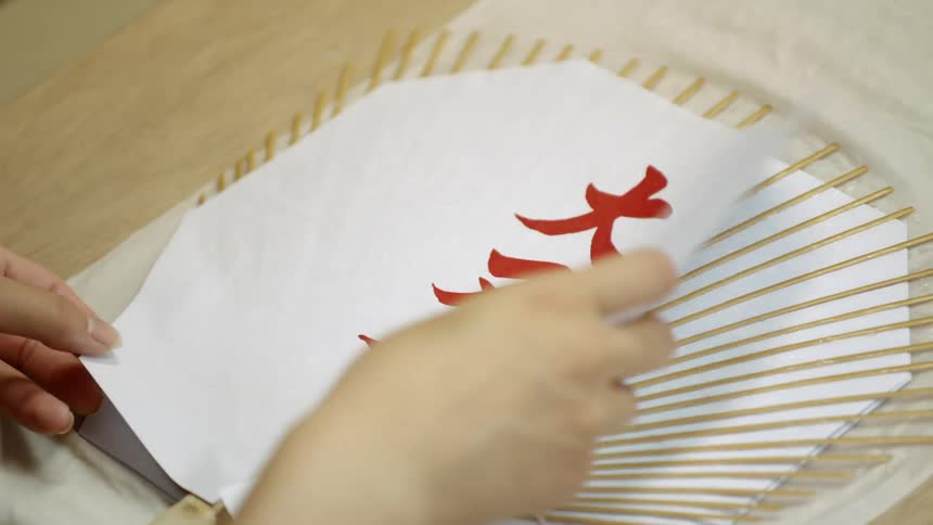 Person assembling a paper fan