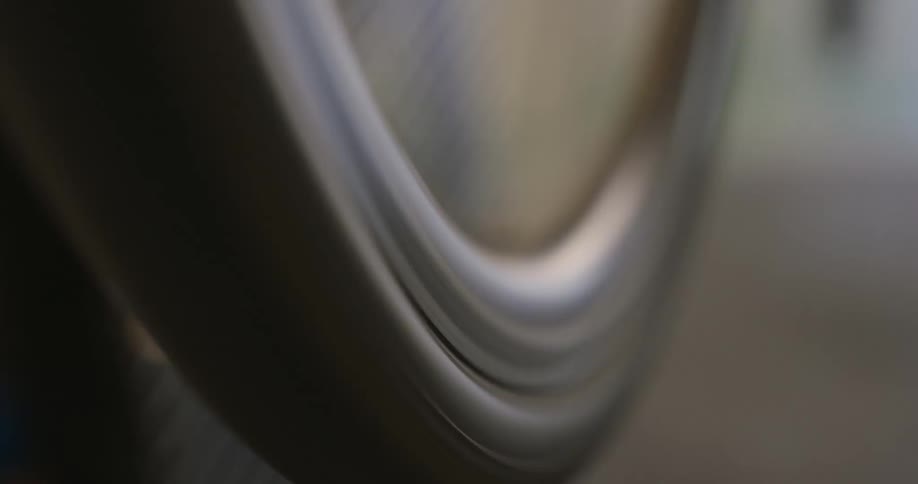 A closeup shot captures the blurred motion of a bicycle wheel spinning rapidly