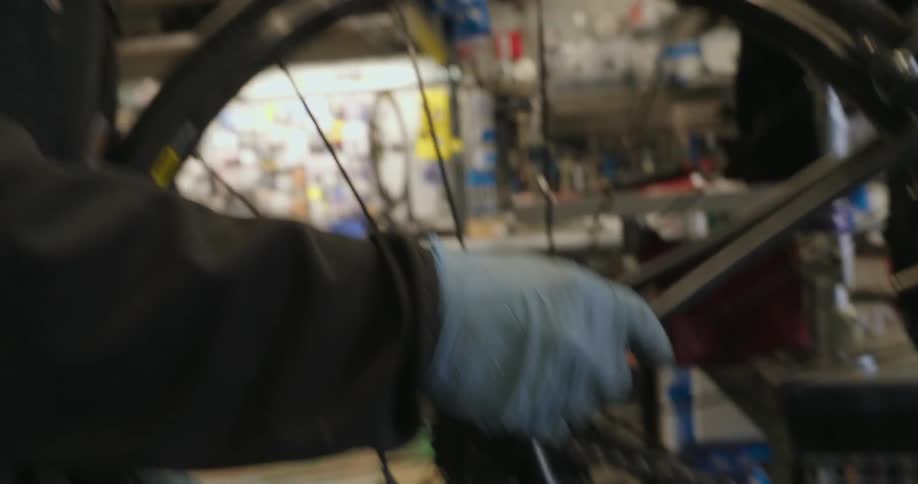 Man with gloves handling a bicycle frame