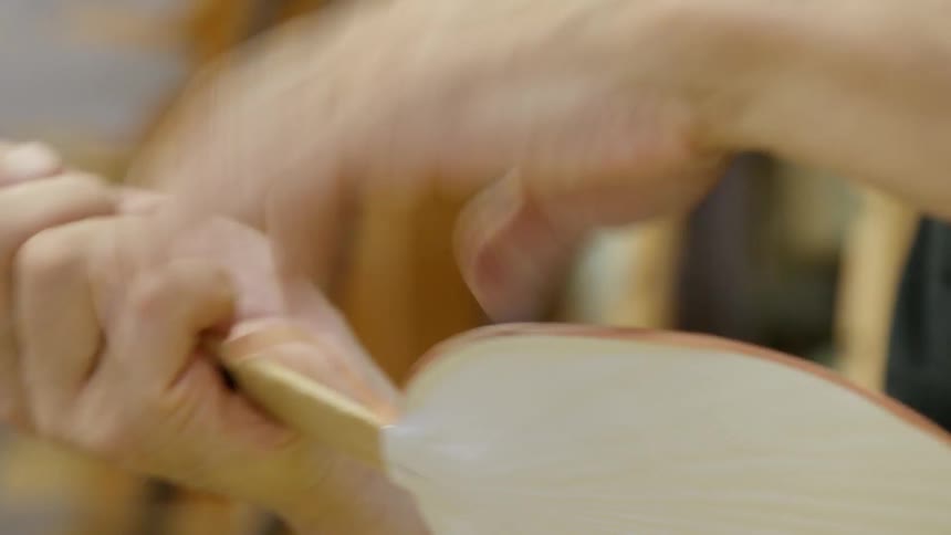 A person assembles a fan with chinese characters