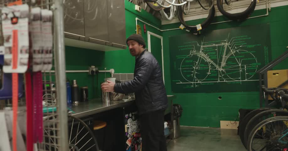 Men smile while talking in a bicycle shop