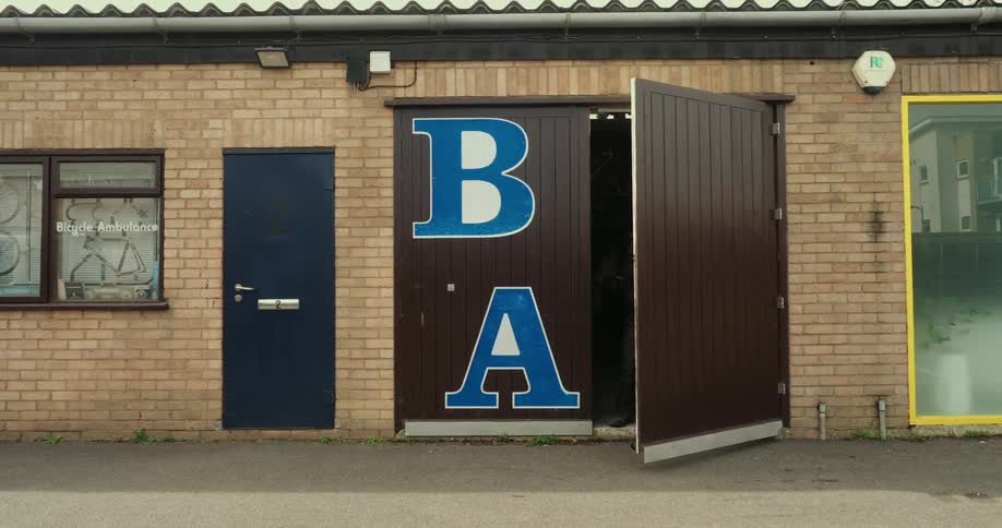 An employee opens the front door to his business and props it open with a metal pipe