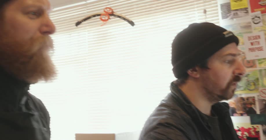 Two men are talking by the window