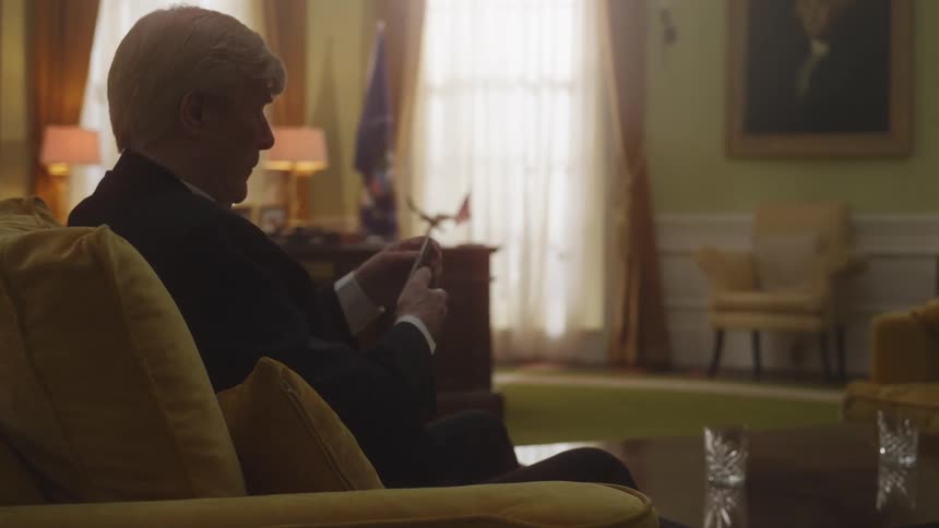 A portrait of an elderly man sitting in the livingroom
