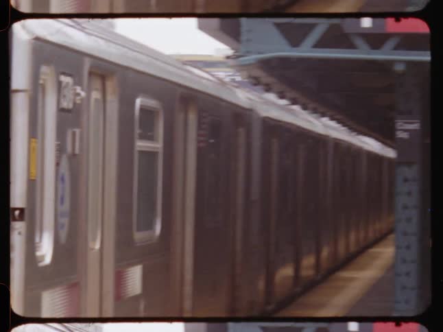 A new york city subway train departs from an outdoor station captured on film