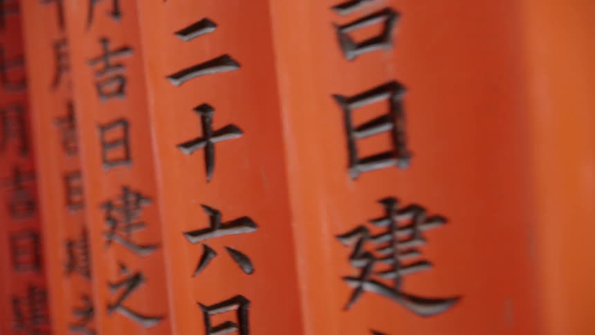 Close up of symbols etched into red pillars