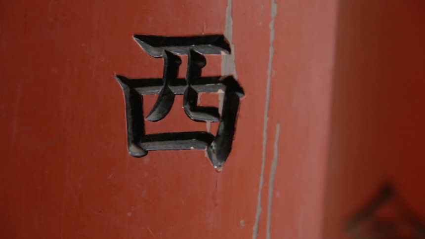Characters carved into orange posts