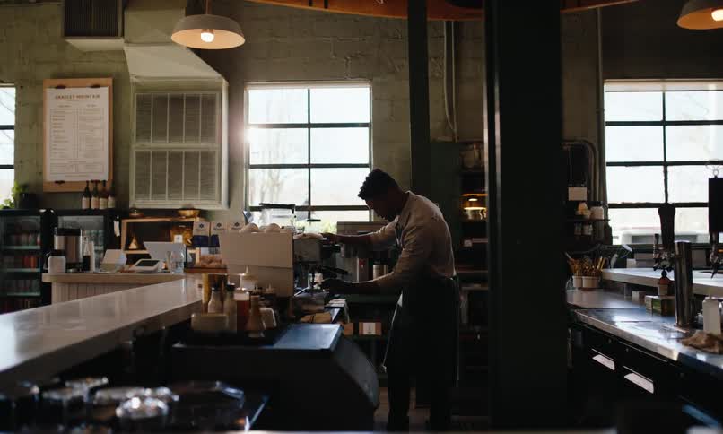 A restaurant worker makes an espresso on the machine