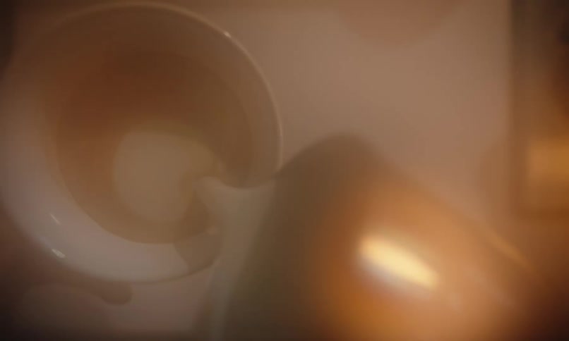 Close up of a coffee drink being prepared with milk poured in