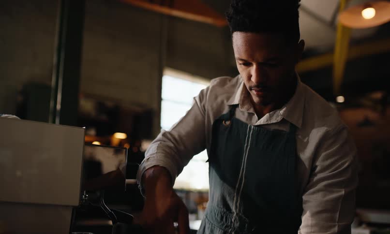 Man in apron preparing a drink