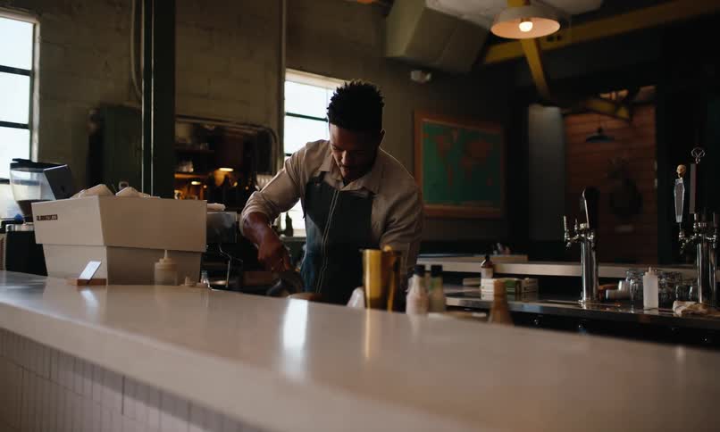 A worker is pouring an espresso in the cafe