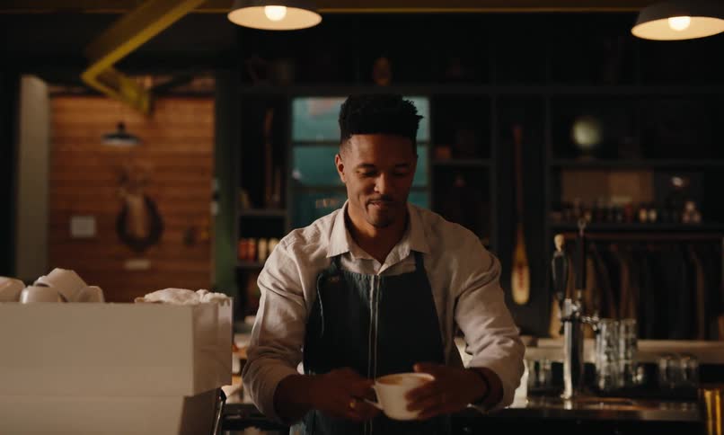 Man in apron serving coffee in a cafe