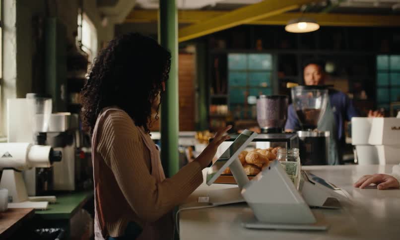 A man comes to the counter and pays with a credit card