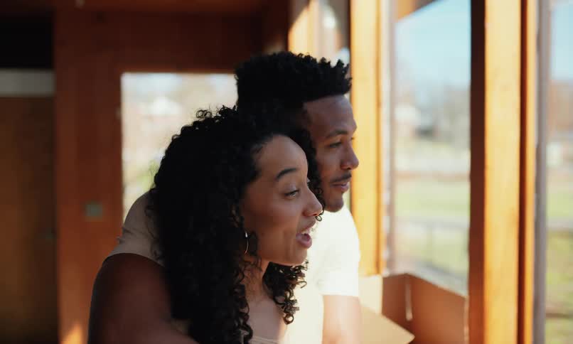 A couple hug by the window