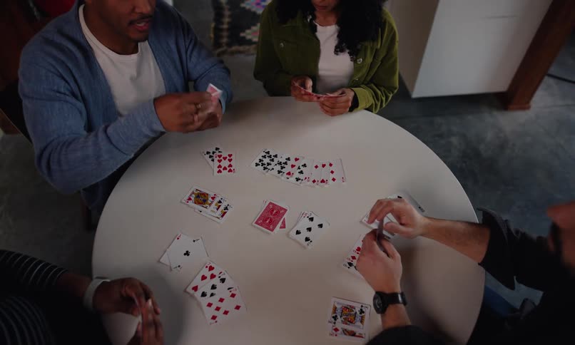 Friends talk while playing cards