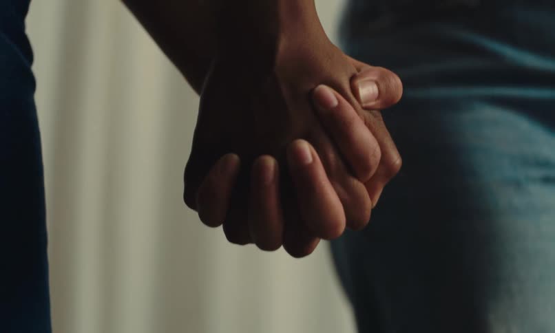 Two women hold hands