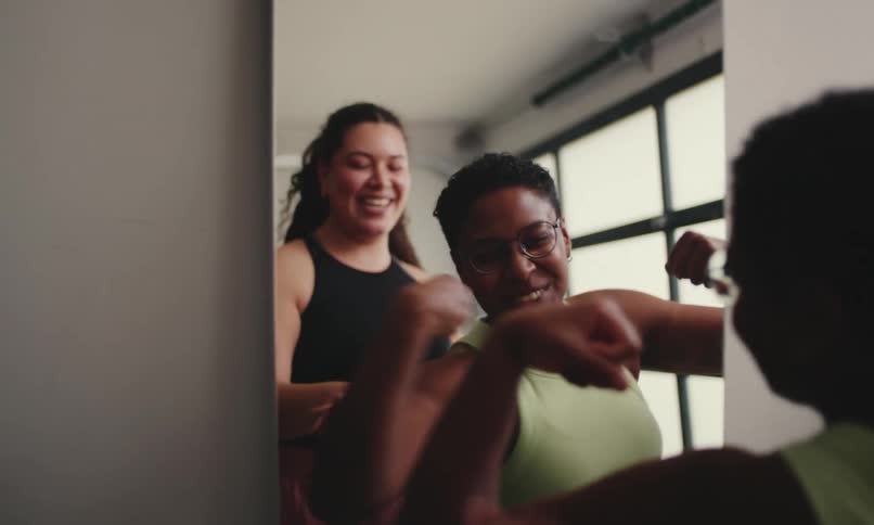 A video clip of two ladies having fun indoor beside the mirror
