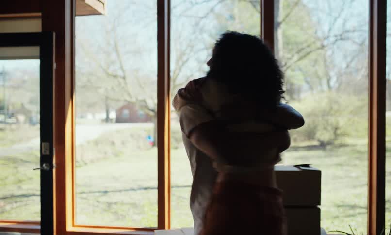 Couple moving into new house then hugging with excitement as they look around
