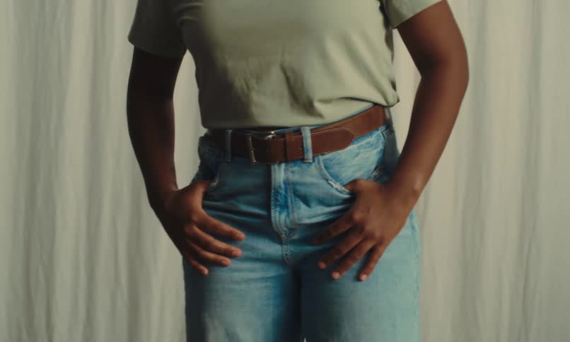 A woman is modeling in front of the curtain