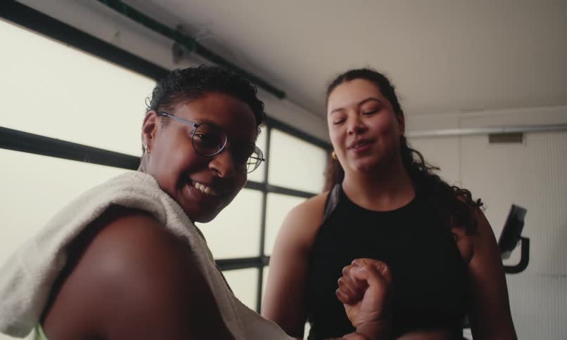 Two women are flexing and laughing