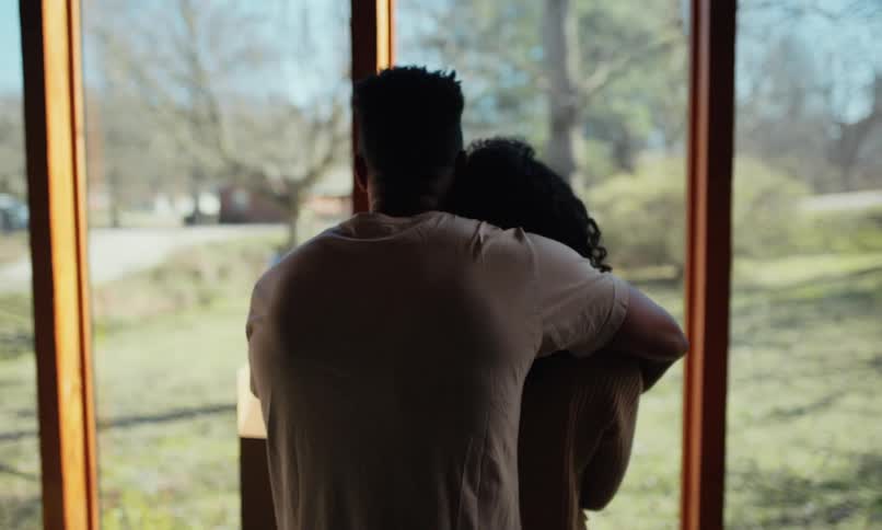 Couple hugging together looking at a view of a garden
