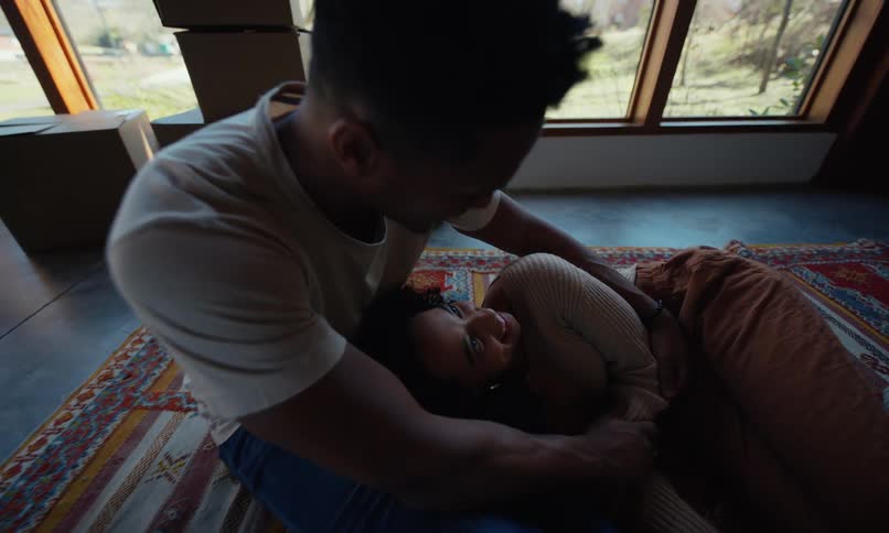 A husband holds his wife who is laying on the floor