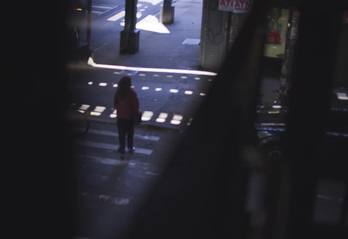 Woman crossing a pedestrian crossing on an urban road in the city