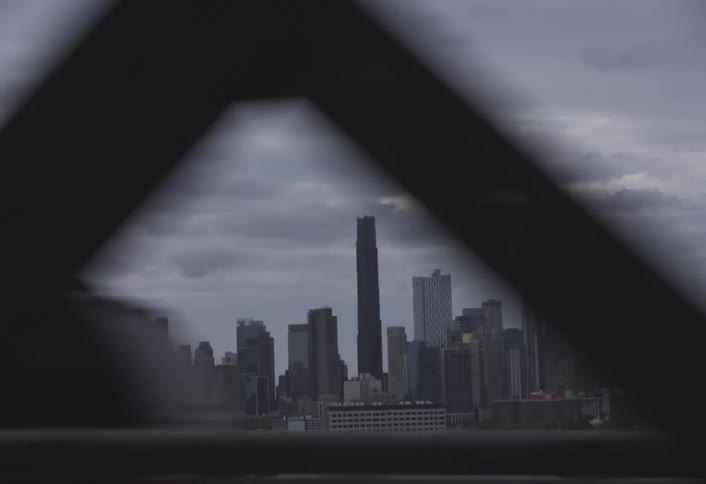 View of a city skyline framed through a bridge structure captured from a fastmoving vehicle