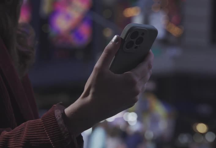 A woman is using her phone in the city