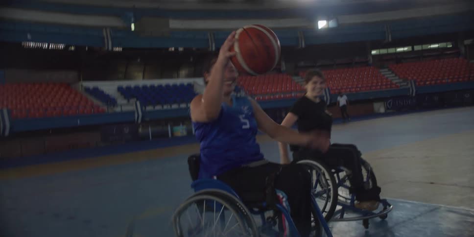 Women are playing basketball in wheelchairs