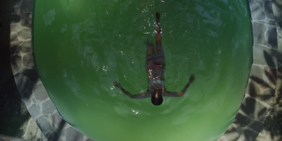 A woman is swimming in the small pool