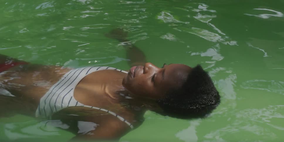 Woman floating and relaxing in the greenish waters