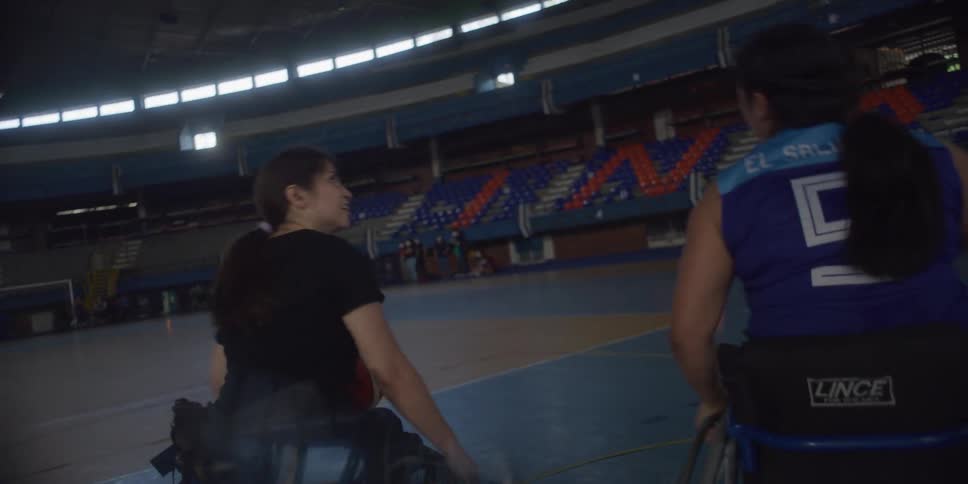 Two women in wheelchairs playing basketball