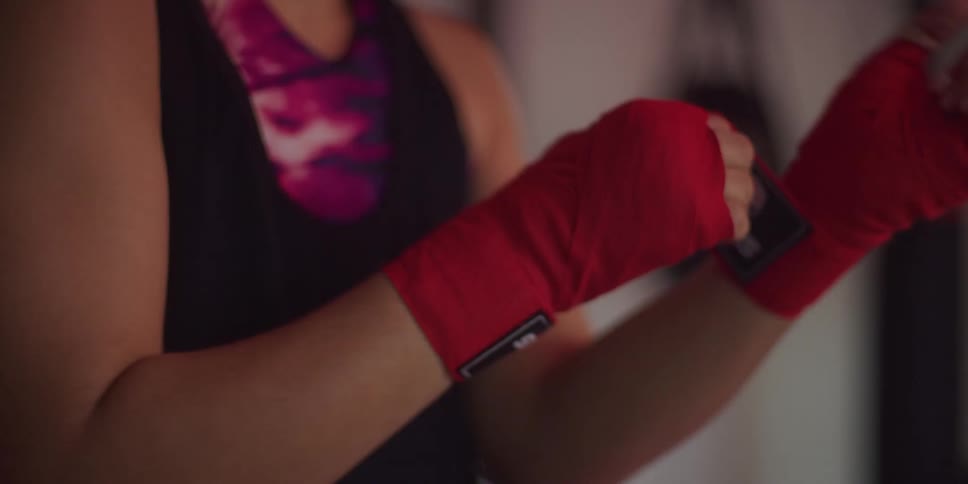 A woman is raping up her hands in the gym