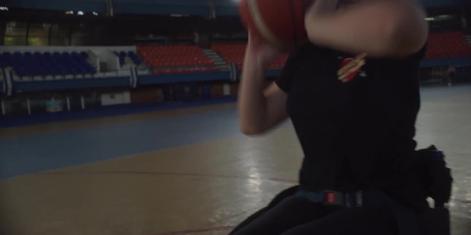 Woman in a wheelchair throwing a basketball